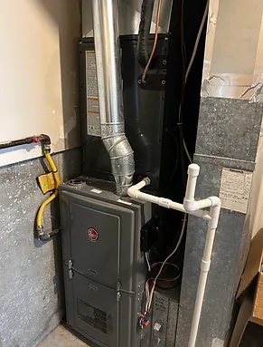 Rheem furnace installed with new flue pipe and condensate lines in a utility area